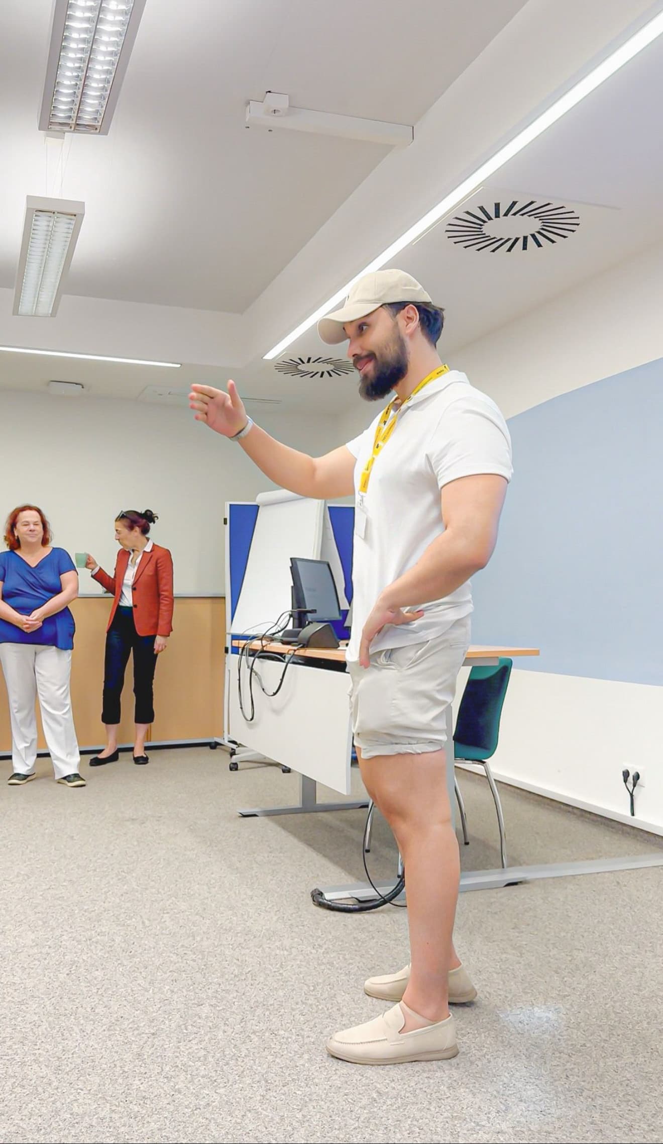 שלו דן עומד ומלמד בכיתה, מסביר בתנועת יד